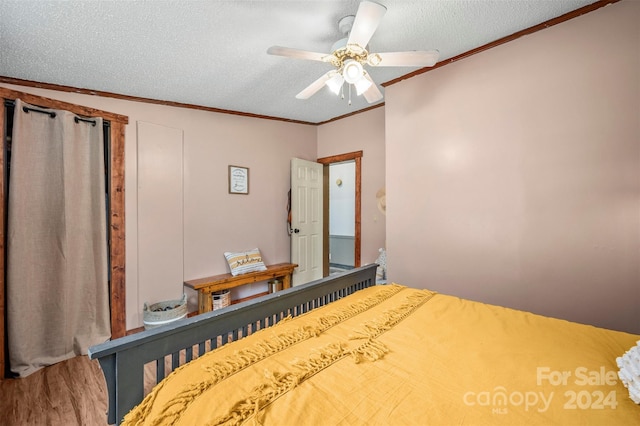 unfurnished bedroom featuring ceiling fan, ornamental molding, wood-type flooring, and a textured ceiling