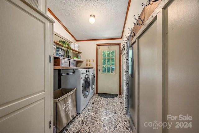 laundry area with light tile patterned floors, washing machine and clothes dryer, a textured ceiling, and ornamental molding