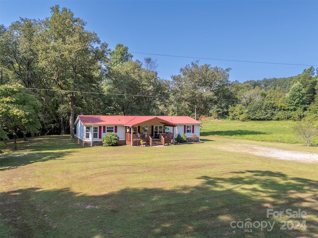 ranch-style house featuring a deck and a front yard