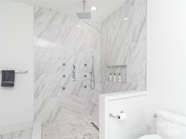 bathroom with toilet and tiled shower