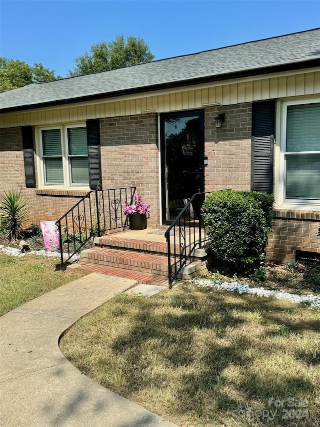 entrance to property featuring a yard