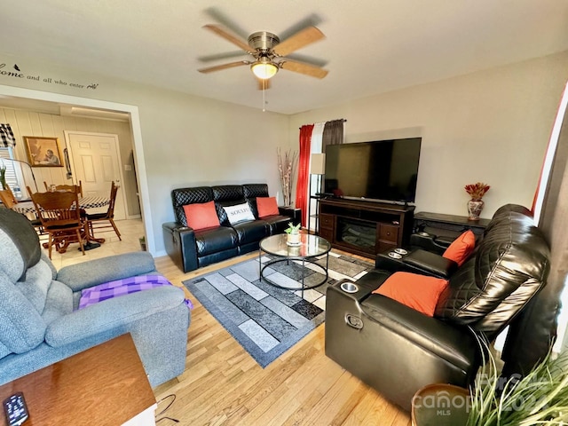 living room with light wood-type flooring and ceiling fan