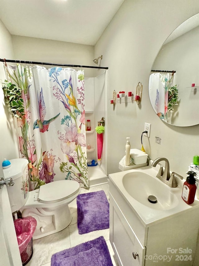 bathroom featuring a shower with shower curtain, tile patterned flooring, toilet, and vanity