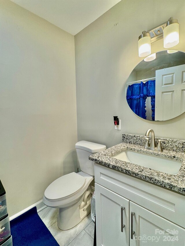 bathroom featuring tile patterned floors, toilet, and vanity