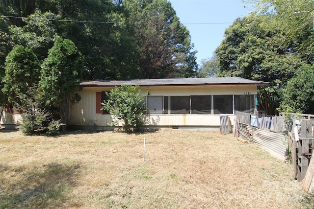 exterior space featuring a sunroom and a lawn