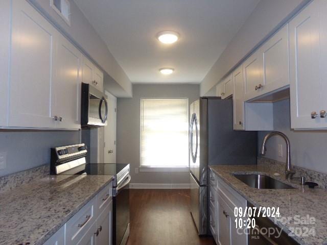 kitchen featuring light stone countertops, white cabinetry, sink, and stainless steel appliances