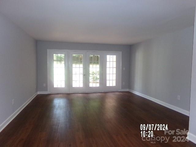 unfurnished room with dark wood-type flooring and french doors