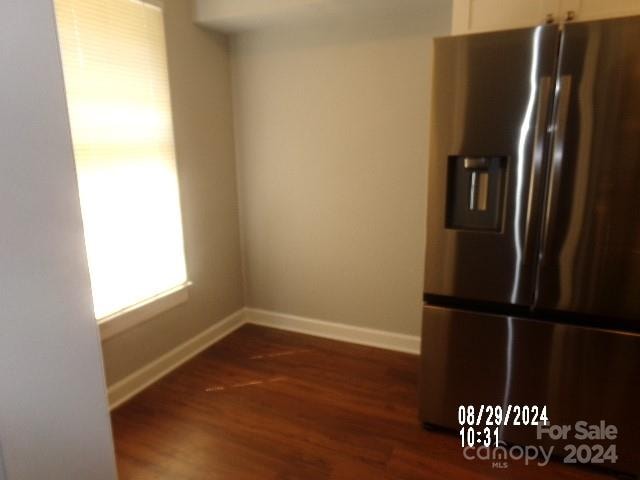 kitchen featuring white cabinetry, stainless steel fridge, and dark hardwood / wood-style flooring