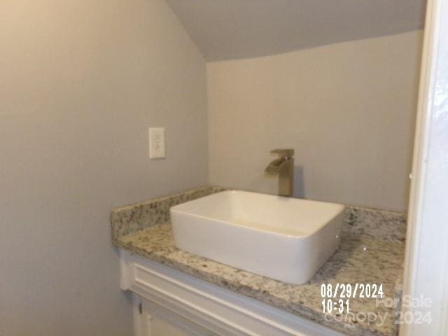 bathroom with vanity and lofted ceiling