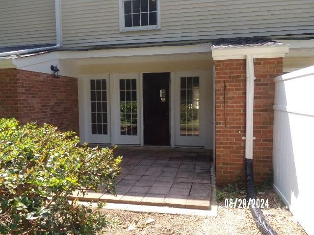 view of exterior entry featuring a patio area