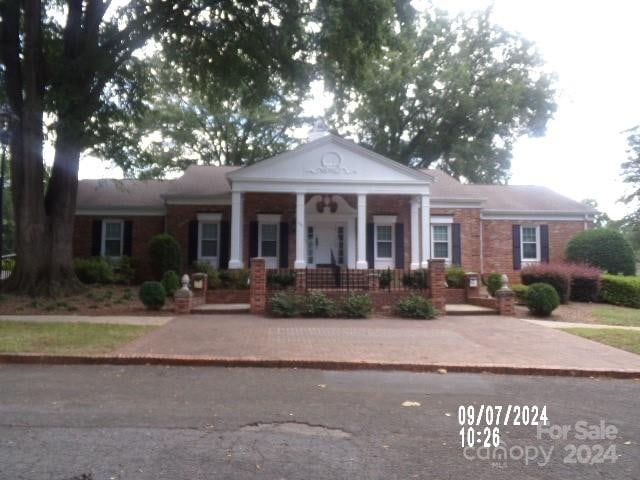 greek revival inspired property featuring a porch