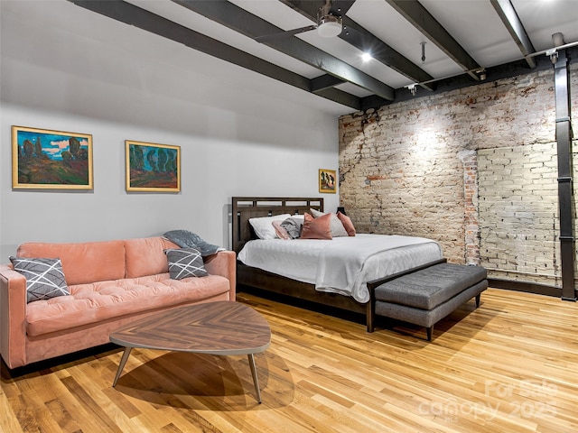 bedroom featuring beamed ceiling and wood finished floors