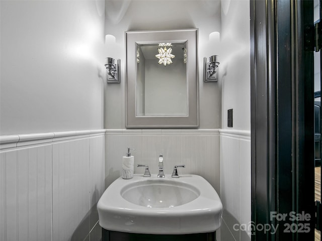 bathroom featuring a wainscoted wall and a sink