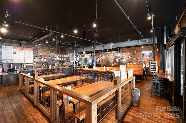 dining room featuring a workshop area, wood-type flooring, and visible vents