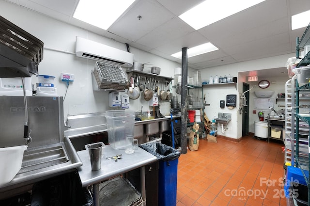 kitchen with a wall unit AC and a paneled ceiling