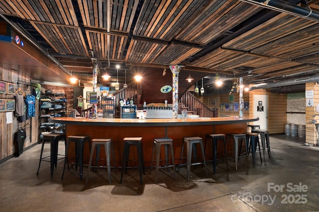 bar featuring a bar and concrete flooring