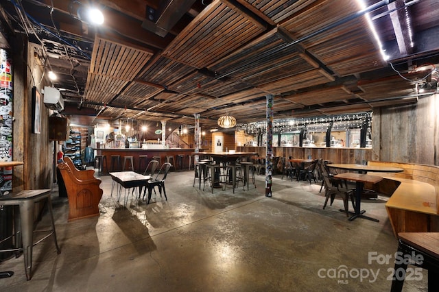 dining space with concrete flooring and a bar