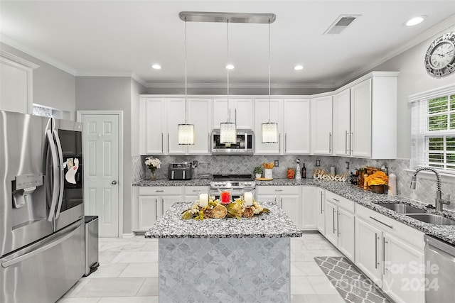 kitchen featuring pendant lighting, white cabinetry, light stone counters, sink, and appliances with stainless steel finishes