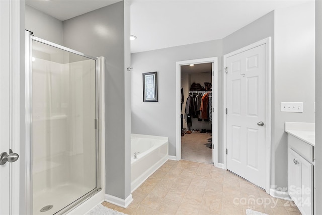 bathroom with tile patterned flooring, independent shower and bath, and vanity