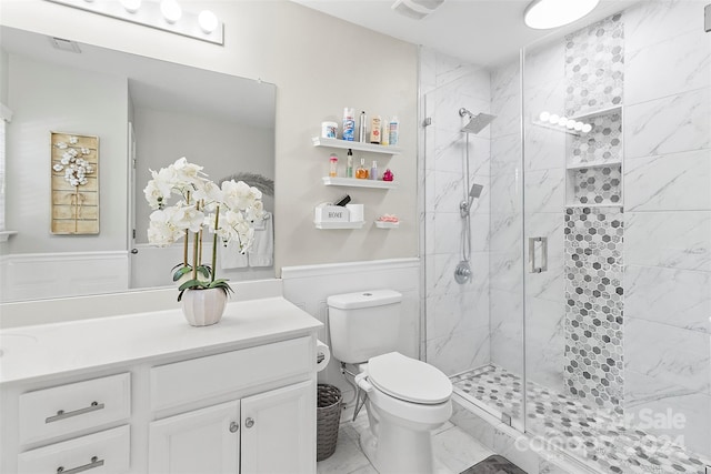 bathroom with a shower with shower door, toilet, and vanity