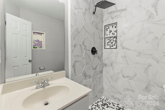 bathroom with vanity and a tile shower