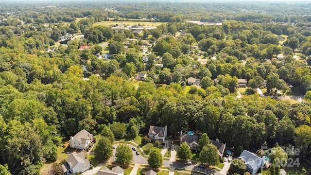 bird's eye view featuring a wooded view and a residential view