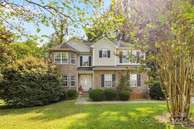 view of front of home with a front lawn and brick siding