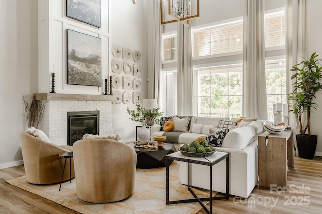 837 Lake Forest Drive Nottingham, Belmont, NC 28012 - living area featuring a towering ceiling, a fireplace, light wood-style flooring, and a chandelier