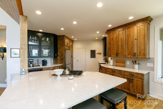 kitchen with a kitchen bar, stainless steel appliances, kitchen peninsula, and light hardwood / wood-style floors