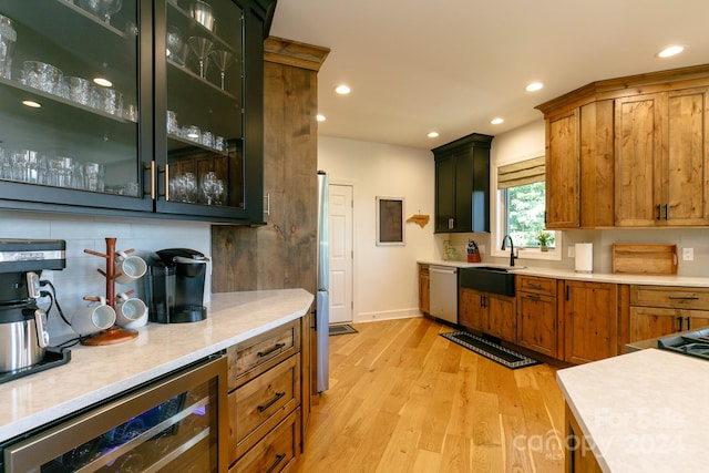 kitchen with dishwasher, light hardwood / wood-style flooring, beverage cooler, backsplash, and sink