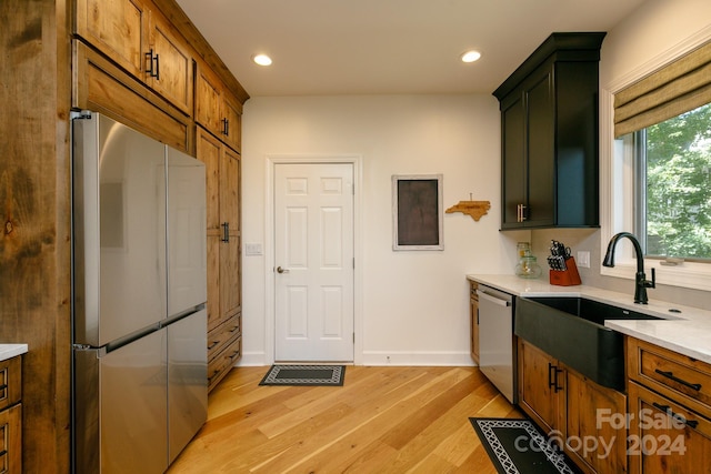 kitchen with light hardwood / wood-style flooring, stainless steel appliances, and sink