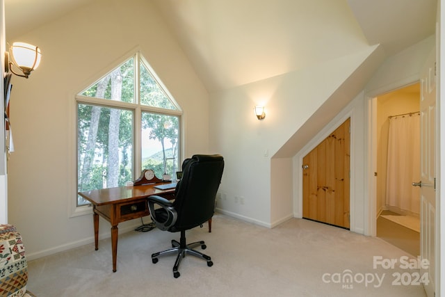 carpeted home office featuring vaulted ceiling