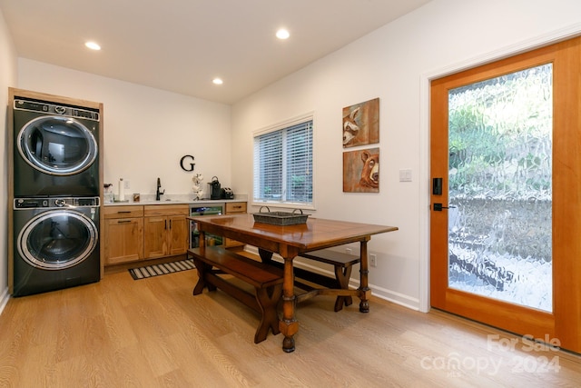 interior space featuring wine cooler, stacked washer and clothes dryer, sink, and light hardwood / wood-style floors