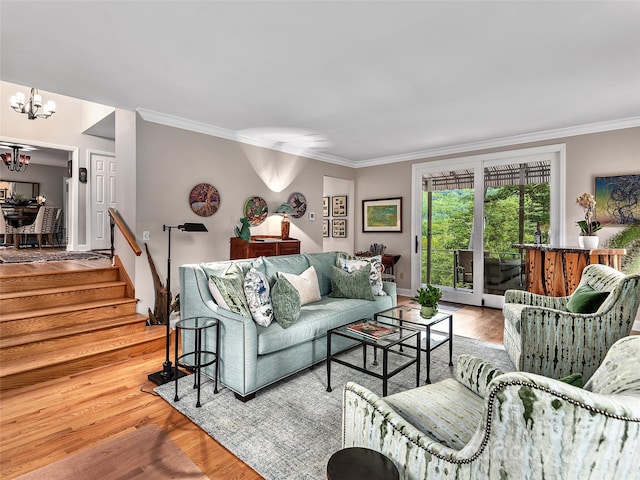 living room featuring ornamental molding, an inviting chandelier, and light hardwood / wood-style flooring