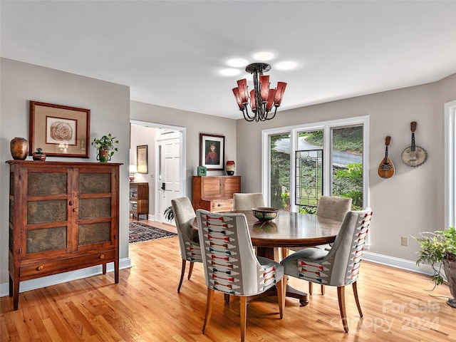 dining room with light hardwood / wood-style flooring and an inviting chandelier