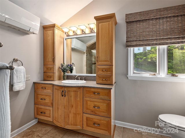 bathroom with vanity, vaulted ceiling, baseboards, and a wall mounted AC