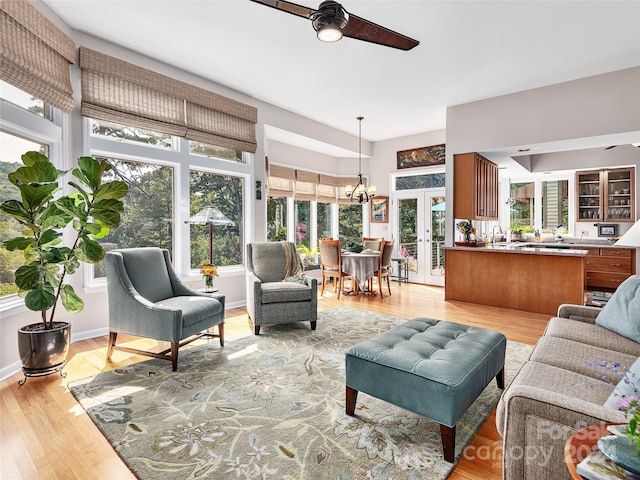 living room with ceiling fan, light wood-type flooring, and french doors