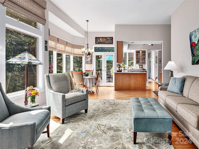 living room featuring light wood-type flooring, french doors, and a healthy amount of sunlight