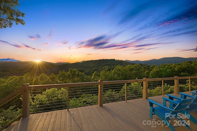 deck at dusk featuring a mountain view