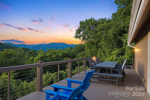 deck at dusk featuring a mountain view