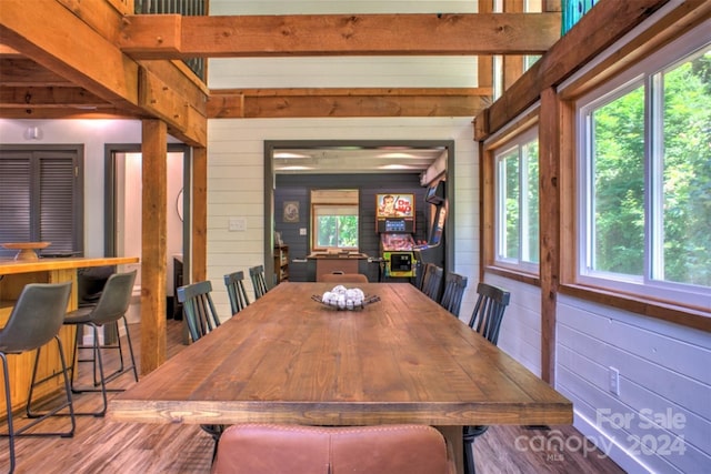 dining room featuring wood-type flooring and wooden walls