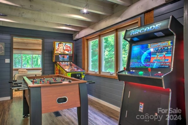 rec room with wood-type flooring, wooden walls, and beam ceiling