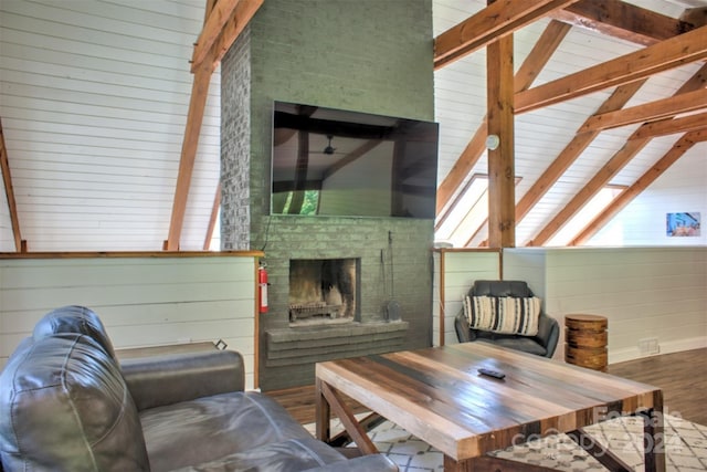 living room featuring a wealth of natural light, wood walls, a brick fireplace, and vaulted ceiling with beams