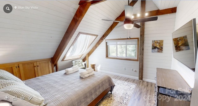 bedroom featuring ceiling fan, wood walls, light wood-type flooring, and lofted ceiling with beams