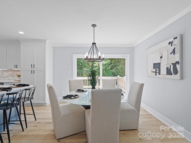 dining space featuring crown molding, a chandelier, and light hardwood / wood-style floors