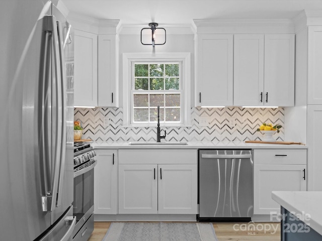 kitchen with white cabinets, decorative backsplash, sink, and stainless steel appliances