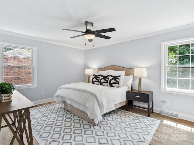 bedroom featuring ceiling fan, crown molding, and multiple windows