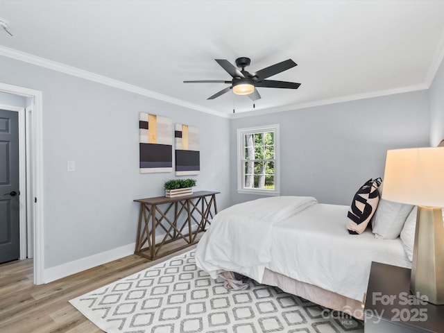 bedroom with ceiling fan, ornamental molding, and light hardwood / wood-style flooring