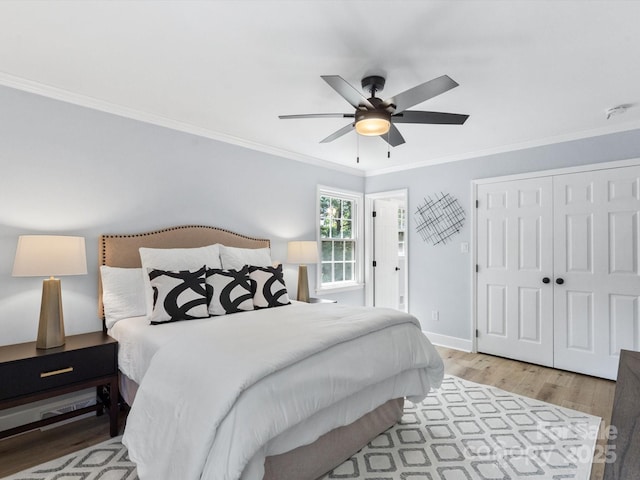 bedroom featuring ceiling fan, hardwood / wood-style floors, a closet, and ornamental molding