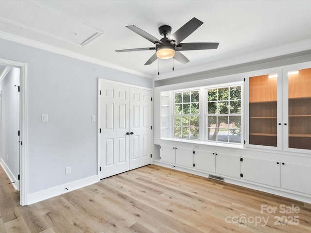 interior space with ceiling fan, a closet, ornamental molding, and light hardwood / wood-style flooring